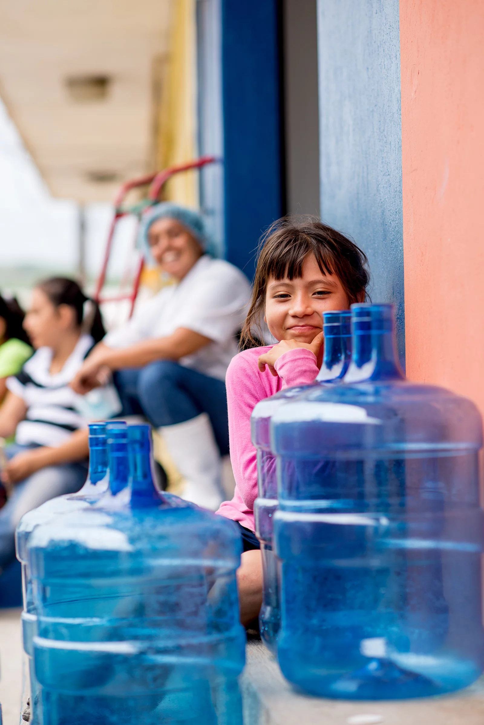 Little girl smiling with water jugs